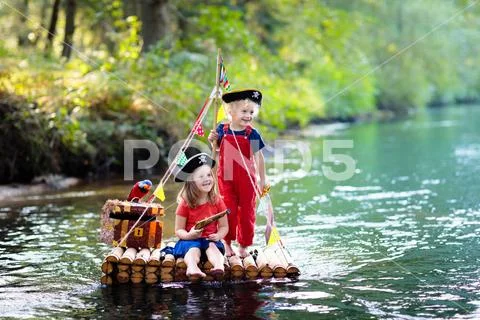 Kids playing pirate adventure on wooden raft Stock Photos