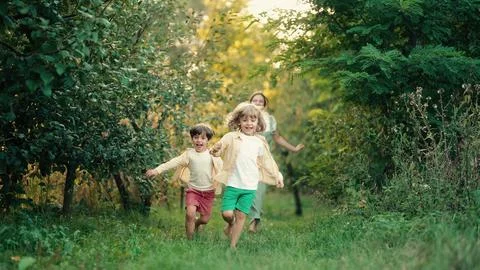 Kids playing running on plot in country house. Ecological life outside city Fotos de archivo