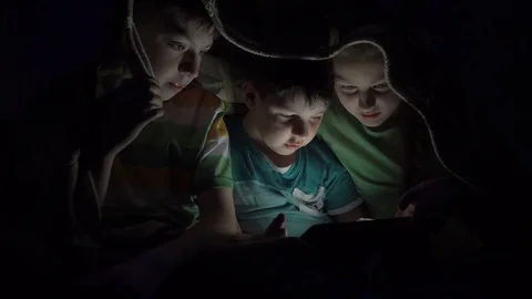 Kids playing in the tablet under the covers Stock Footage 78226686