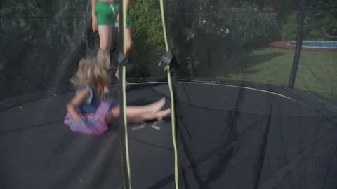 Kids playing on trampoline viewed through safety net Stock-Footage 255446984