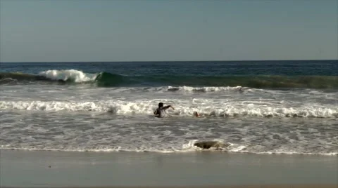 Kids playing with waves in the ocean Stock Footage 45988083