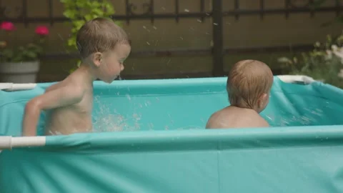 Kids in pool having fun happy family concept. two male siblings splash in water Video stock 242008212