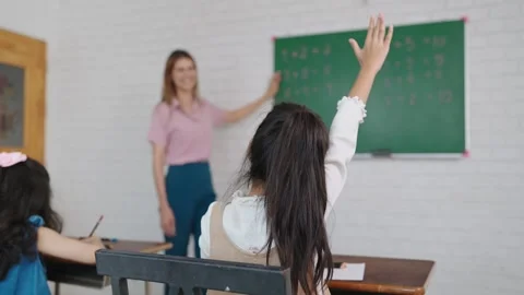 Kids raising hands teacher explaining lesson functioning in classroom at school. Video stock 248546737