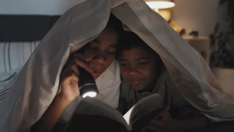 Kids Reading Book with Flashlight Stock Footage 193339608