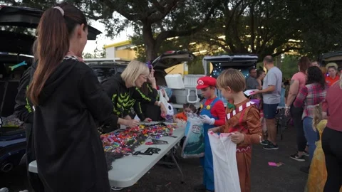 Kids Receiving Candy at Trunk-or-Treat Table Stock Footage 318115275
