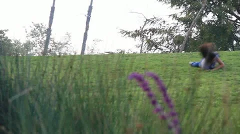 Kids rolling down grassy hill at La Brea Tar pits museum Los Angeles 4983 Stock Footage 18968374