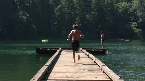 Kids Running And Jumping Into Lake Stock Footage