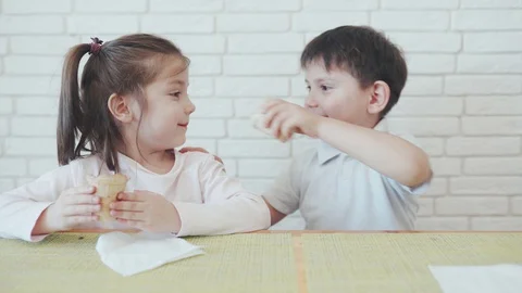 Kids in self-isolation. Boy and girl eating ice cream. Children sitting at home Stock-Footage 128428833
