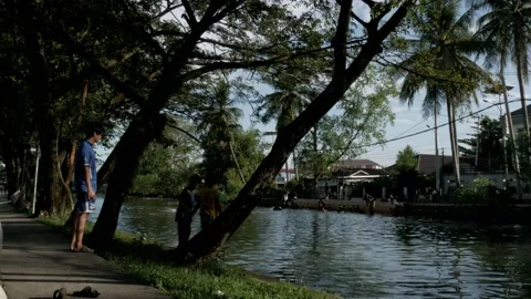 Kids spending time by playing on the riverside of river canal Stock Footage 132449096