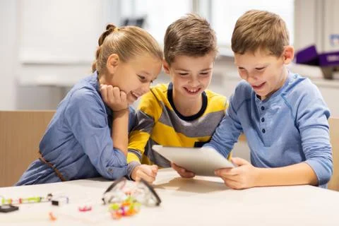 Kids with tablet pc programming at robotics school Stock-Fotos