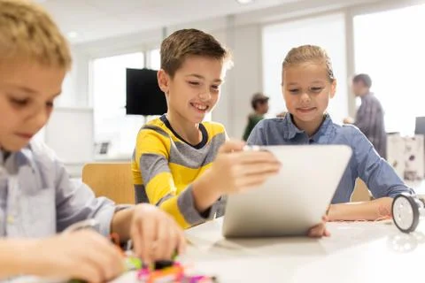 Kids with tablet pc programming at robotics school Stock-Fotos