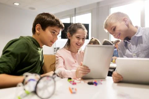 Kids with tablet pc programming at robotics school Stock-Fotos