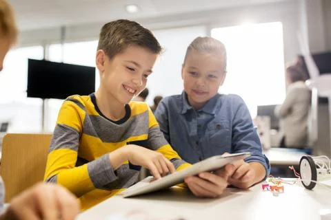 Kids with tablet pc programming at robotics school Stock-Fotos