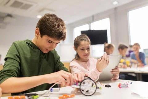 Kids with tablet pc programming at robotics school Stock-Fotos