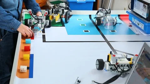 Kids testing their just built computerized robots on special table Stock Footage 87040539