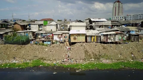 Kids throw rocks at a drone flying past slum housing Jakarta, Indonesia Stock Footage 78574052