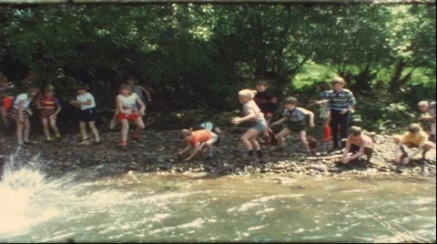 Kids throwing stones in river, 1960s (vintage 8 mm amateur film) Stock Footage