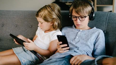 Kids Using Phone in Sofa Foto stock