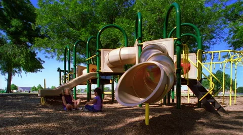 Kids using playground equipment in a park Stock Footage 59525973
