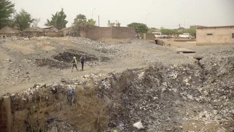Kids walking over garbage dump in Africa Stock Footage 75597506