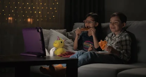 Kids watching video on digital tablet on the sofa at home at night Stock Footage 249287525