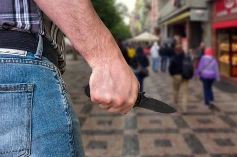 Killer is attacking with knife on crowd of people in public place - murder and c Stock Photos