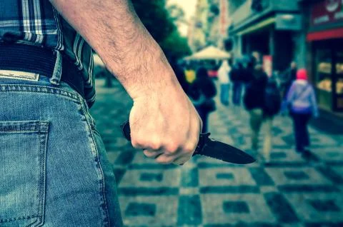 Killer is attacking with knife on crowd of people in public plac Stock Photos