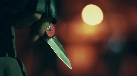Killer with blade in hand shining at night Stock Footage 66780236