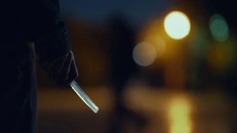 Killer with blade in hand shining at night stalking at park Stock Footage 73891754