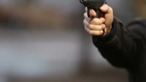 Killer with gun close-up on dark background Stock Footage 117913868