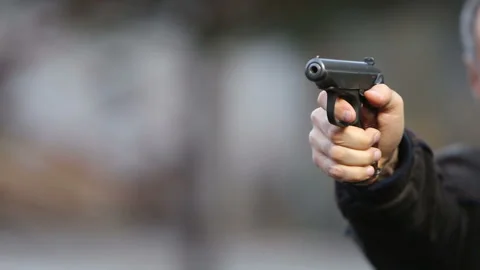 Killer with gun close-up on dark background Stock Footage 117915392