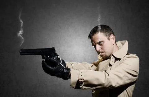 Killer standing on dark background after shooting Stock Photos