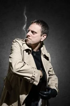 Killer standing on dark background exctracting gun Stock Photos