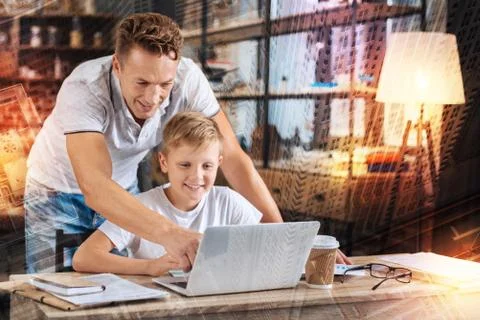 Kind father pointing to the screen while standing near his smiling son Stockfoto's