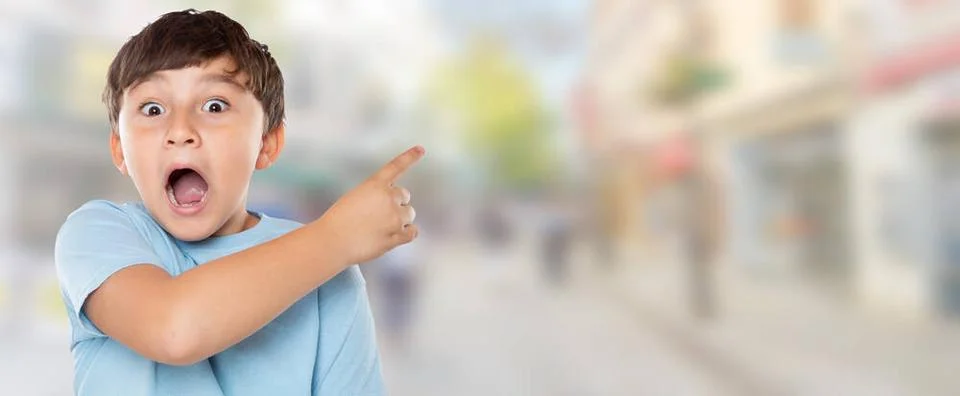 Kind Junge ist erstaunt überrascht zeigt auf Werbung in der Stadt Erfolg m.. Stock Photos