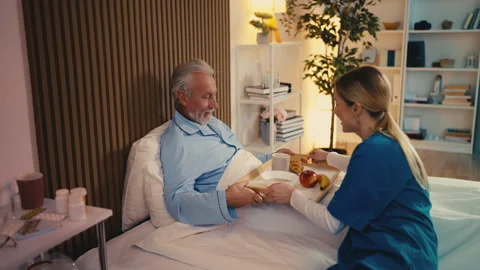 Kind nurse bringing breakfast to bedridden senior patient, assisted living Stock Footage 279177440