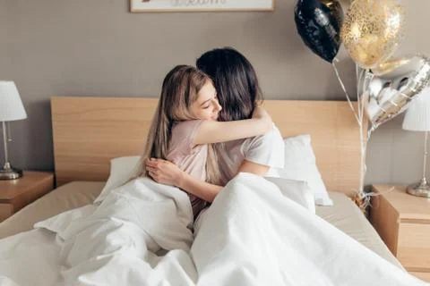 Kind sister kissing her elder sister good night. Stock Photos