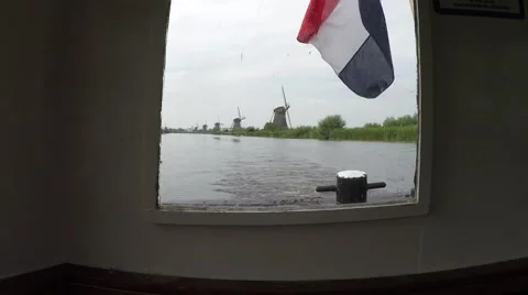 Kinderdijk view from the back of a touring boat inside the cabin dutch flag 4k Stock Footage 53229332