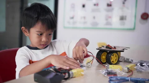 Kindergarten asian student learn in coding robot car and electronic board cable Stock Footage 247107397