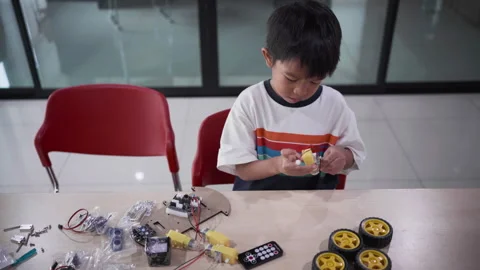 Kindergarten asian student learn in coding robot car and electronic board cable Stock Footage 247107399