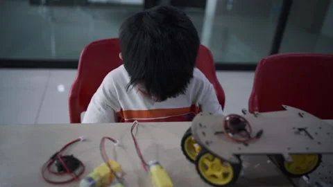 Kindergarten asian student learn in coding robot car and electronic board cable Stock Footage 247119066