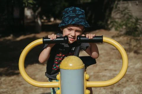 Kindergarten child boy playing with a simulator on playground Stock Photos