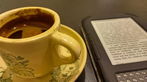 Kindle ebook reader with a cup of coffee in a cafe Stock Photos