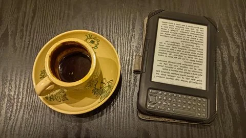 Kindle ebook reader with a cup of coffee in a cafe Stock Photos