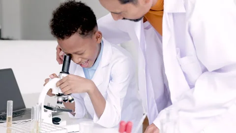 Kindness Hispanic teacher with beard and student in class, African boy focu.. Stock Footage 243659201