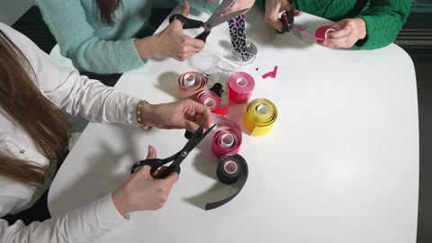 Kinesiotaping. Girls cut multi-colored kinesiotage tape with scissors. Vidéo 236423191