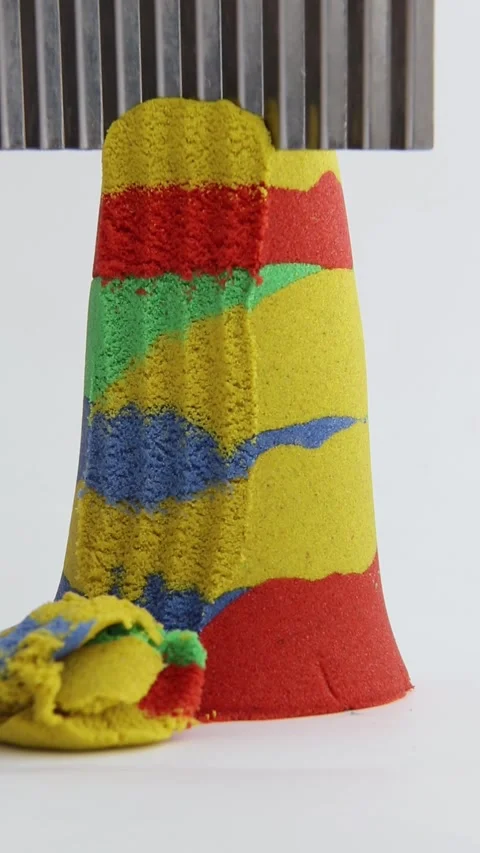 Kinetic sand of different colors of the rainbow is cut with a knife. Stock Footage 277130770
