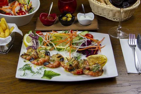 King prawns served on the table with Red wine glass in the background Stock Photos
