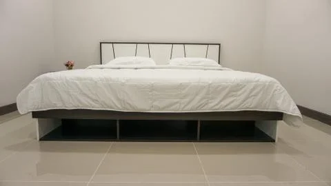 King size or Queen size bed with covers, duvet and pillows. Decorated bedroom Stock Photos