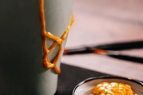 Kintsugi concept. Part of a broken pot with gold glue. Stock Photos